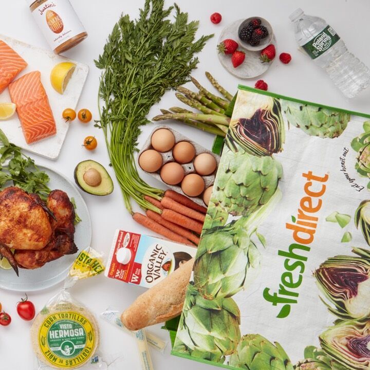 freshdirect bag with a variety of groceries on a white countertop