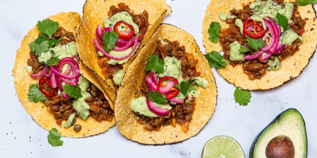 vegan tacos made with lentils in flour tortillas with pickled onions, green sauce, and cilantro