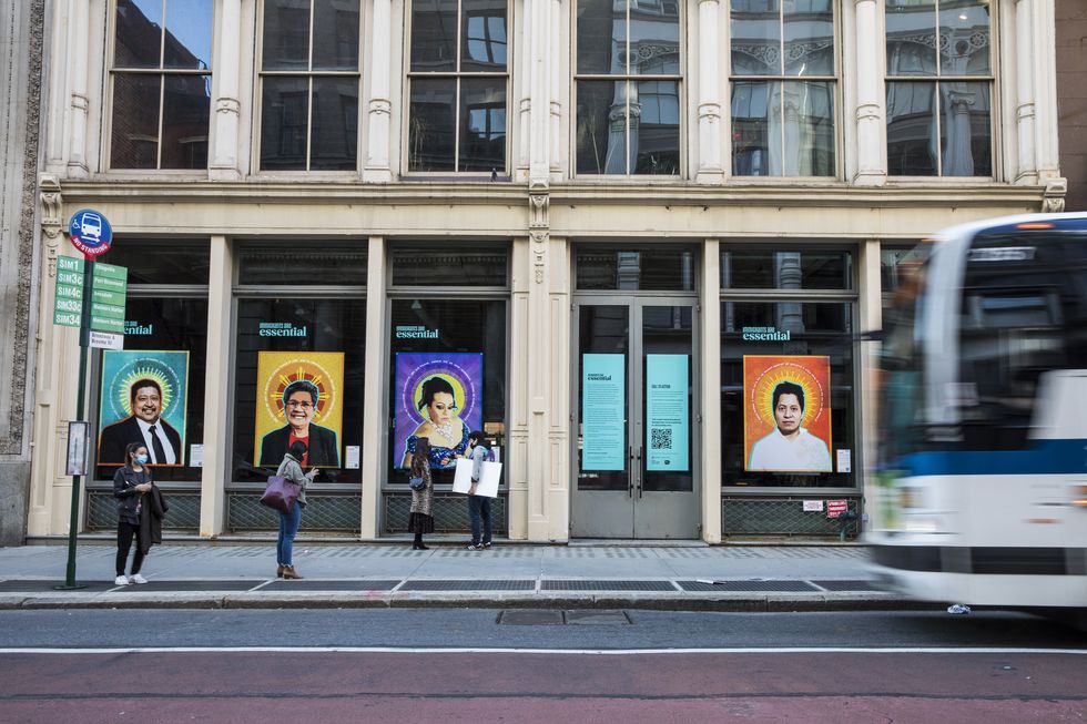 four of the portraits are photographed on the empty storefront as a bus and people pass by