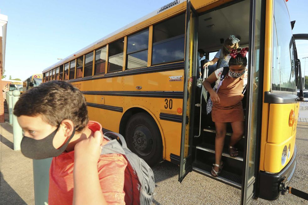 corinth elementary school students exit their bus wearing masks to protect against coronavirus, as they arrive for their first day back to school on monday, july 27, 2020 in corinth, miss adam robisonthe northeast mississippi daily journal via ap