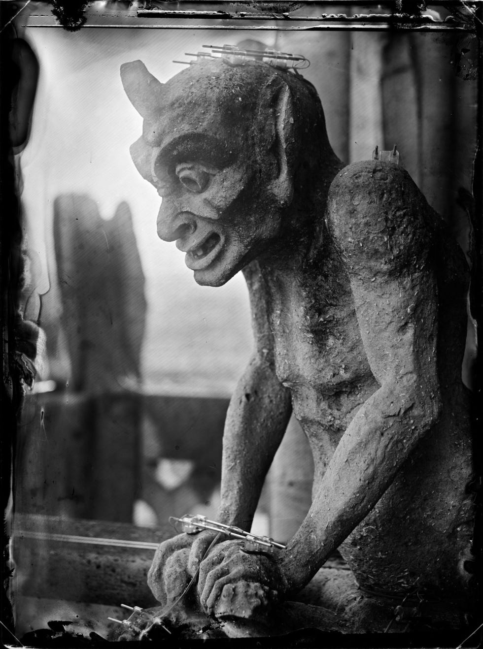 Rechts Op de Gallerie des chimres van de NotreDame is een groot aantal demonen te zien waarvan sommige als waterspuwers fungeren deze demon vermorzelt een kikker