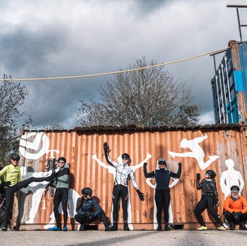 een groep fietsers poseert voor een zeecontainer