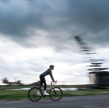 een vrouw rijdt op een racefiets over een industrieterrein