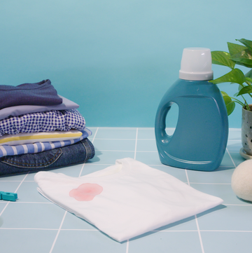 white shirt with blood stain with laundry detergent and dryer balls and clothespins