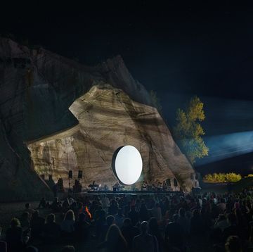 a crowd of people in front of a large rock structure