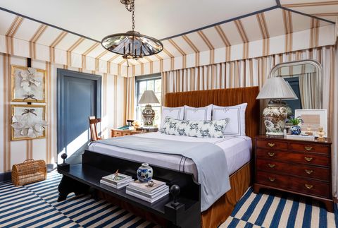 bedroom with wood bed and blue striped carpet and brown striped walls