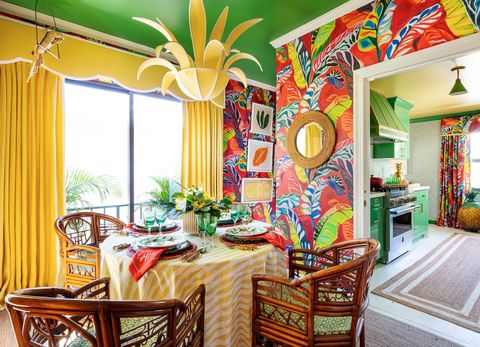 dining room with yellow curtains red palm tree wallpaper and a green ceiling