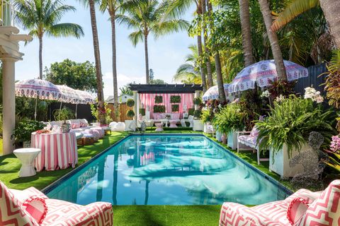 swimming pool surrounded and pink striped beach umbrellas and chairs