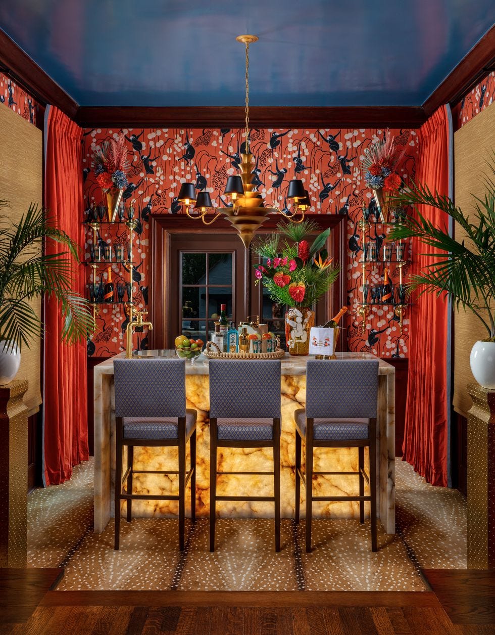 a swanky home bar with a blue ceiling and orange walls and curtains