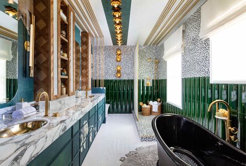 a large bathroom with a dark clawfoot tub and green wall tiles