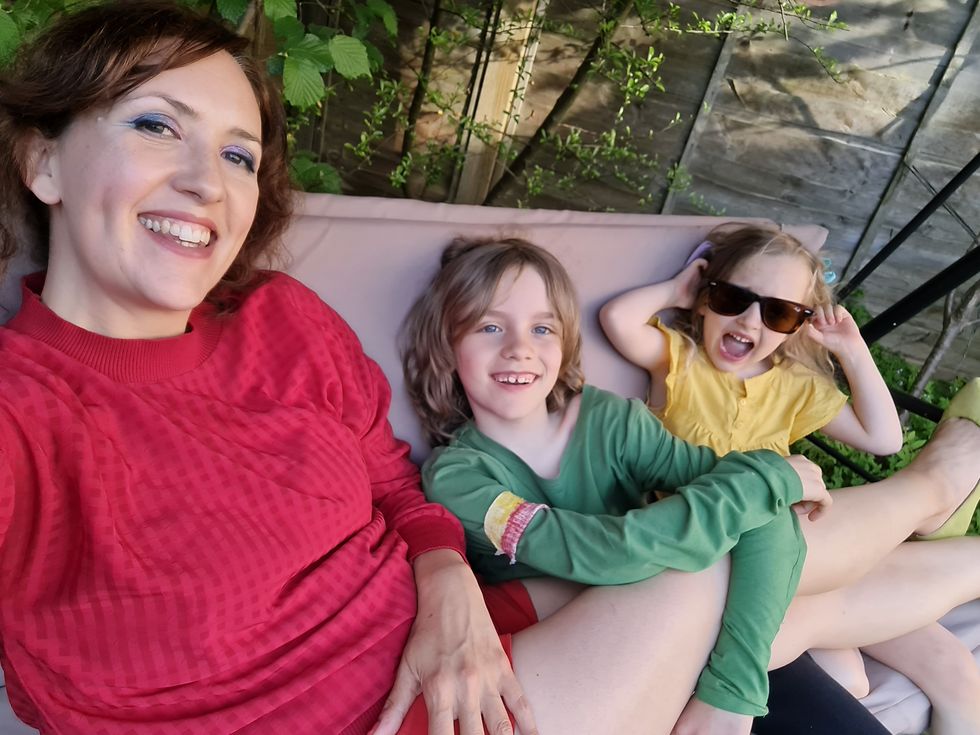 a person and two children sitting on a couch
