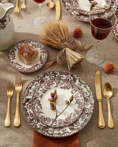 a thanksgiving table with gold flatware