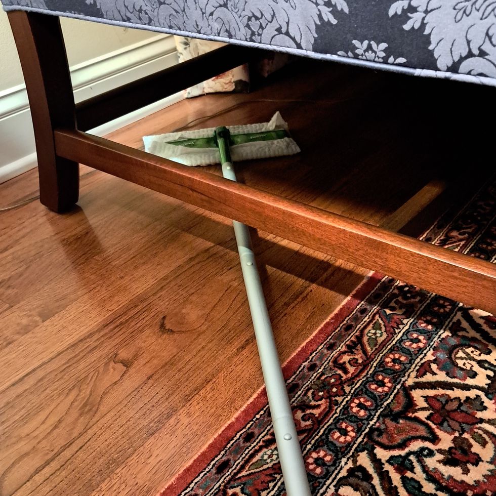 testing a swiffer mop under low furniture