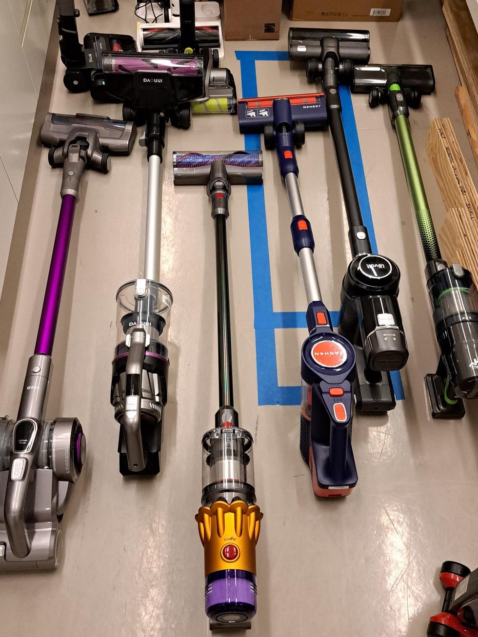 best dyson vacuums collection of stick vacuums displayed on a floor for testing