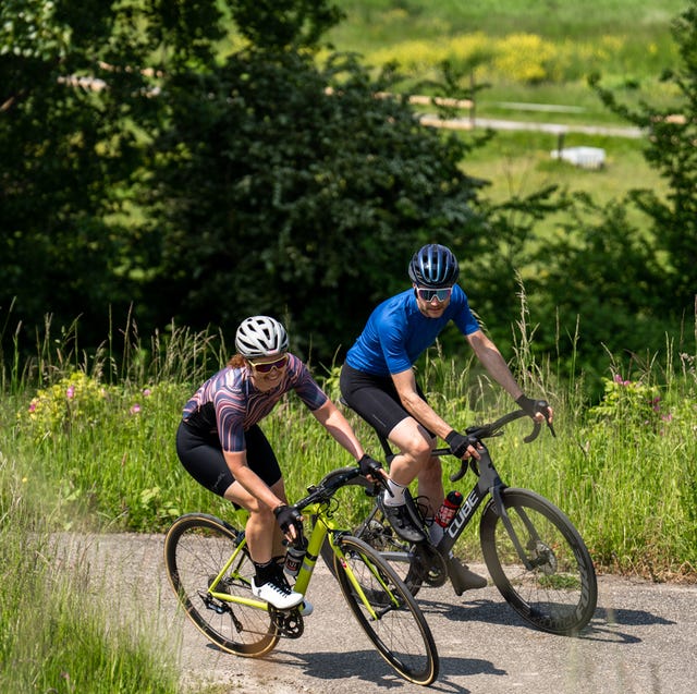 man en vrouw klimmen omhoog op een racefiets