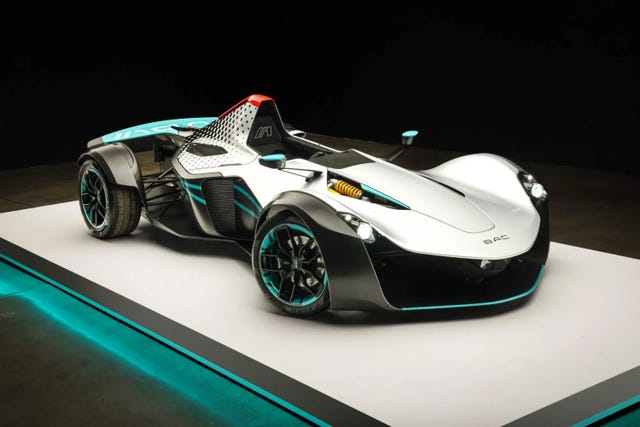 three quarter front view of a single seater sports car with turquoise accents, exposed wheels, and a streamlined body.