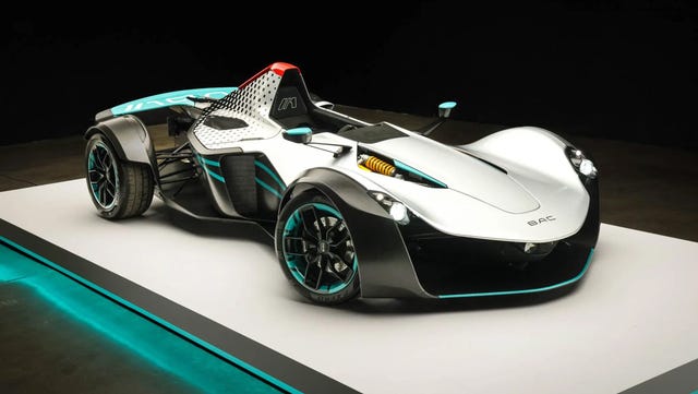 2023 BAC Mono X three quarter front view of a single seater sports car with turquoise accents, exposed wheels, and a streamlined body.