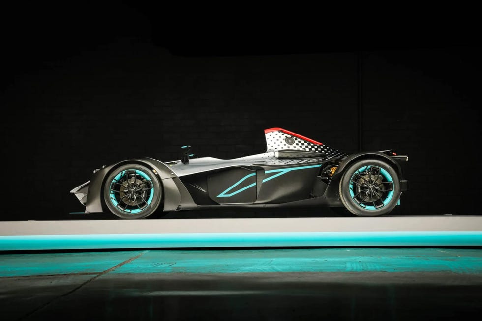 side profile of a single seater sports car with a low slung body, turquoise accents, and exposed mechanical components.