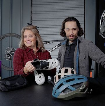 a man and woman sitting at a table with a helmet and a bike