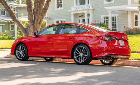 2023 honda civic sedan touring parked on the street in front of a house
