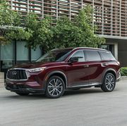 2023 maroon infiniti qx60 suv parked near trees and an apartment building