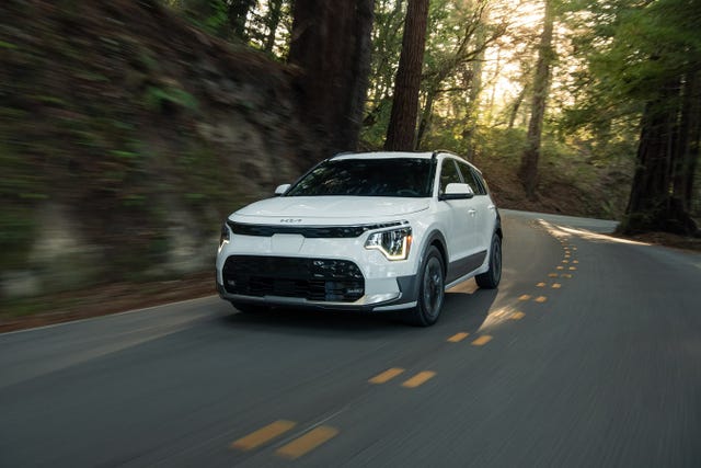 2023 kia niro ev suv driving through the forest