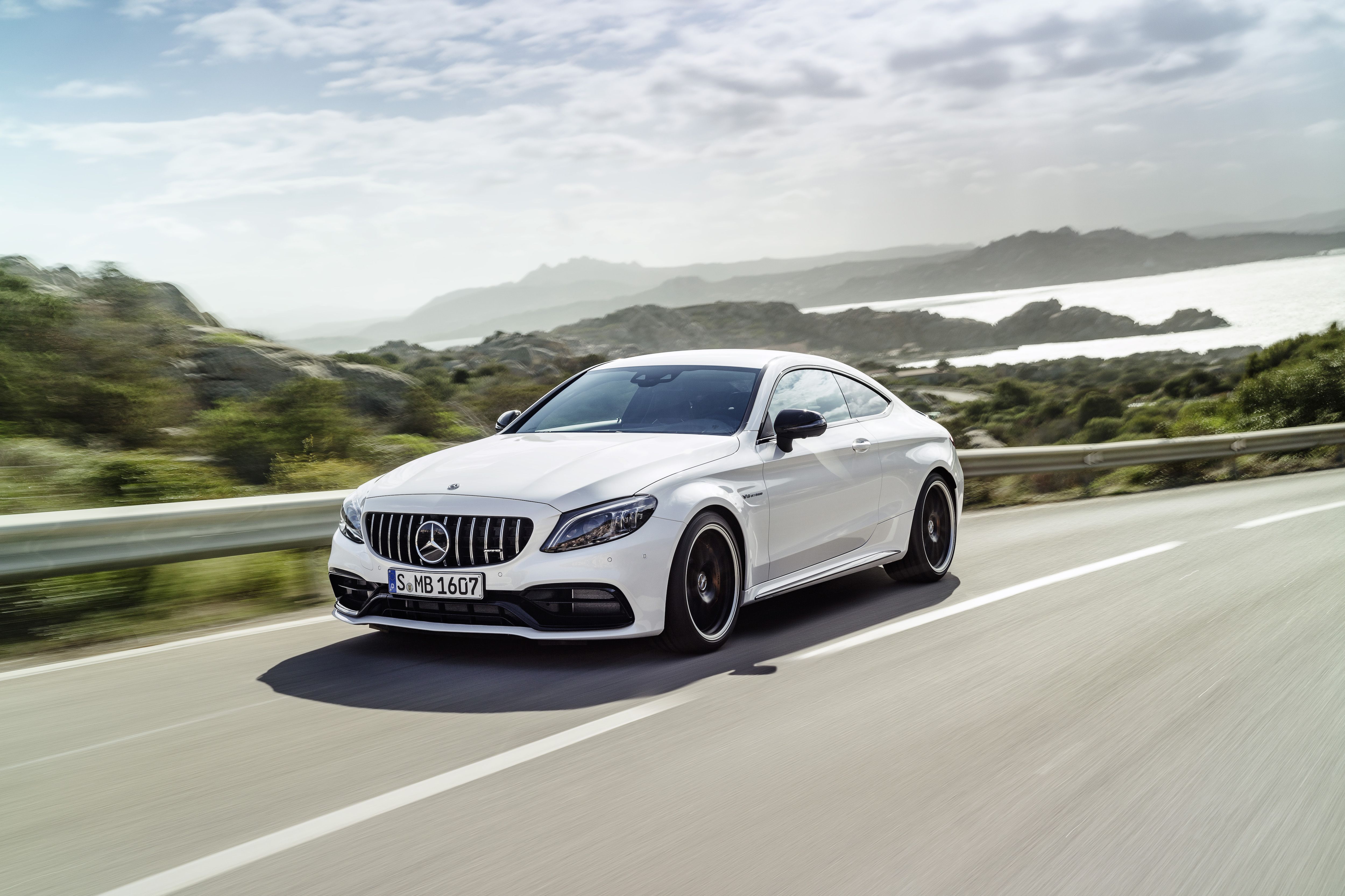 2023 mercedes amg c63 coupe driving down a coastal highway