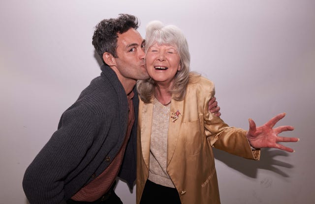 two individuals in a close embrace with one appearing to kiss the other on the cheek