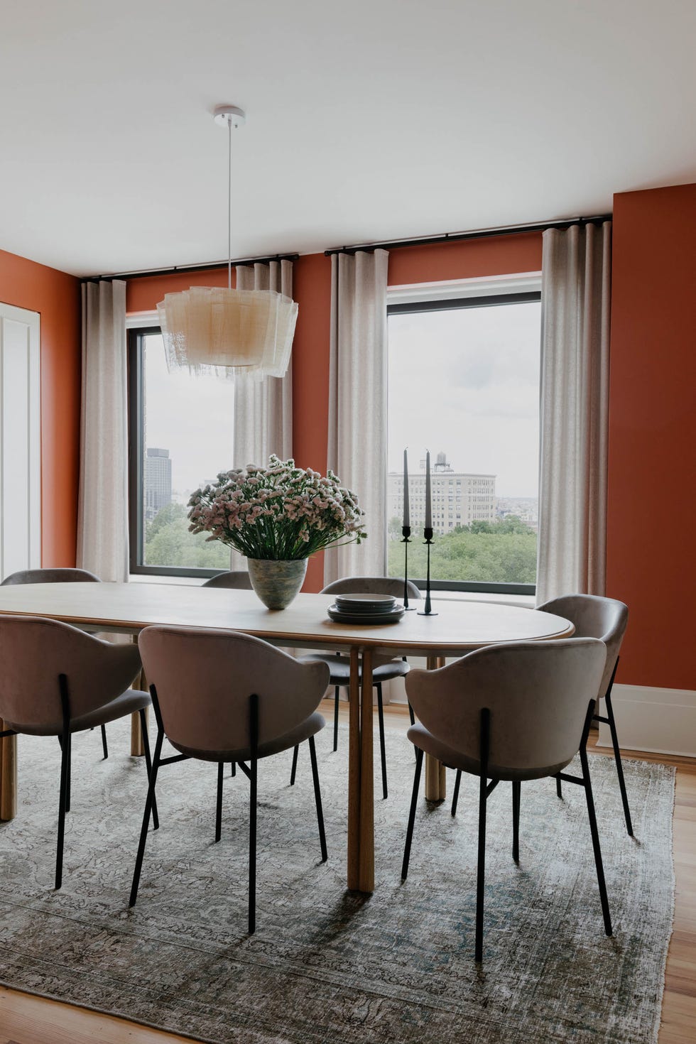 A modern dining area with a wooden table upholstered chairs and red walls a modern dining area with a wooden table upholstered chairs and red walls