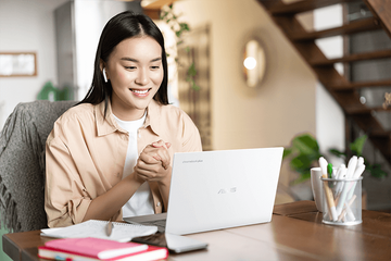 person engaged in a conversation by a laptop on a desk