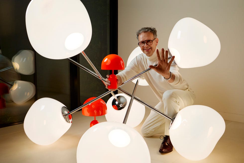 tom dixon sitting with a chandelier and portable lamps