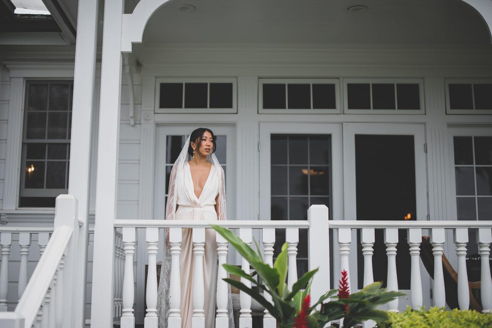 a person in a white dress standing on a porch