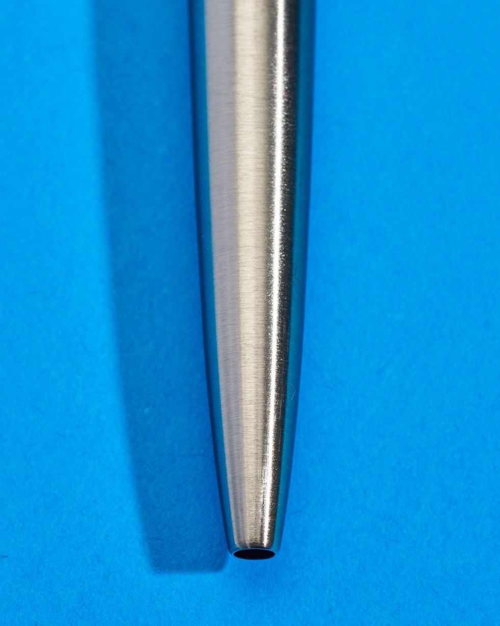 a silver pen on a blue surface