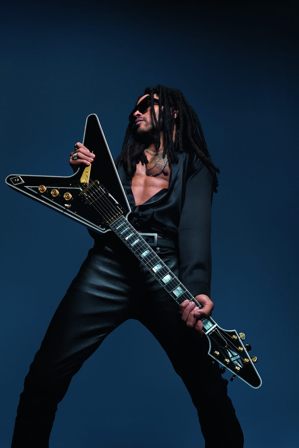 a person striking a rock pose while holding an electric guitar
