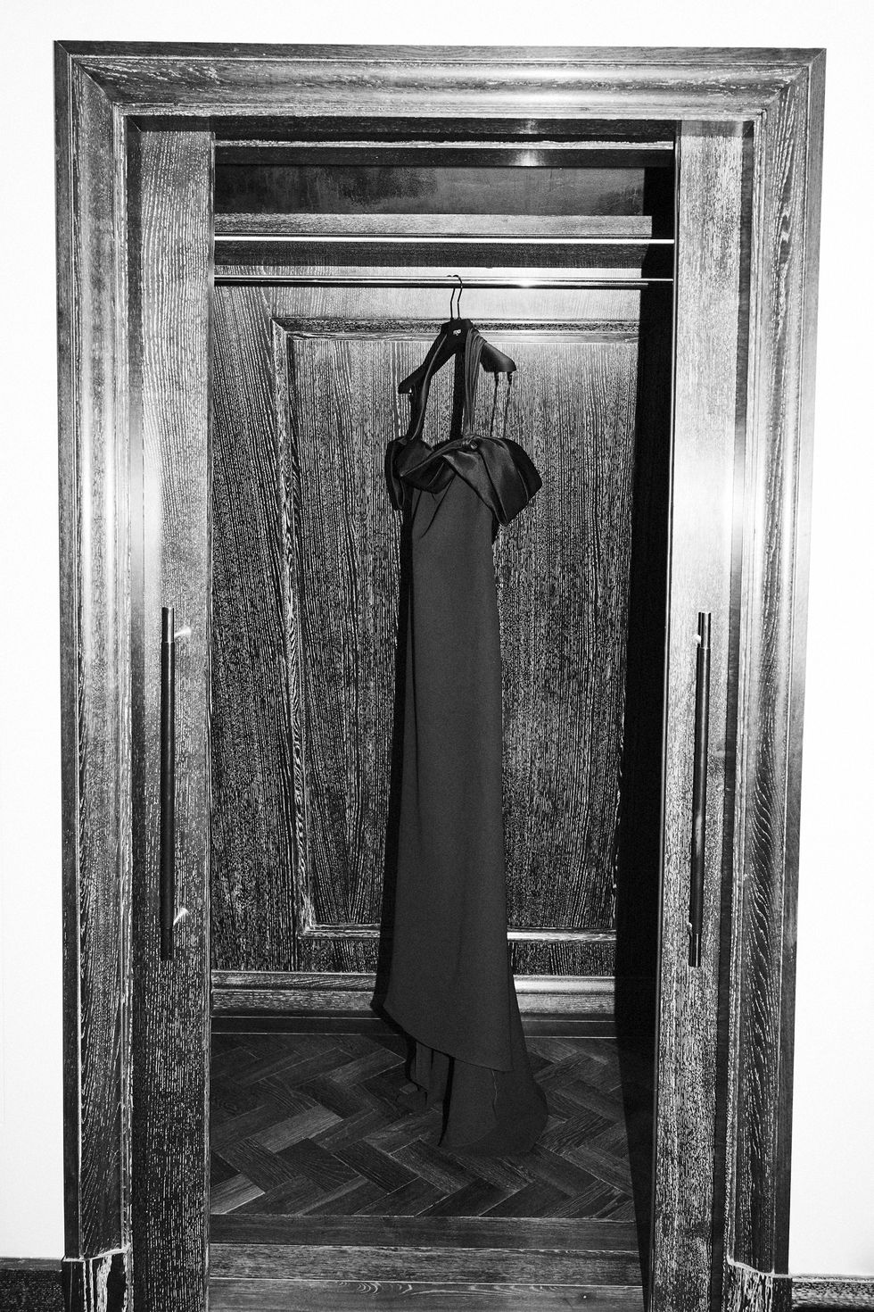 a black and white photo of a dress in a doorway