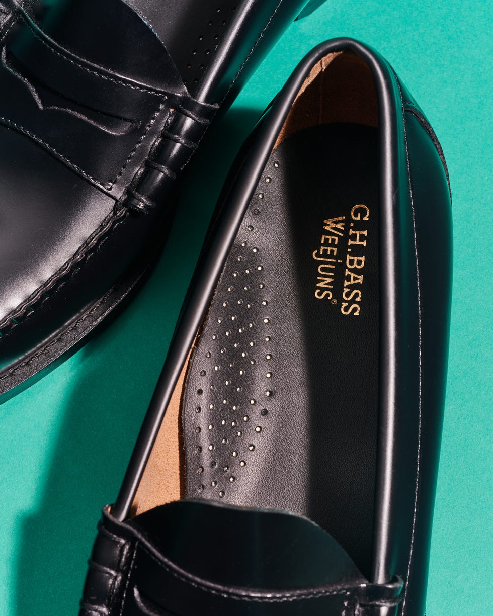 black loafers with gh bass branding on the insoles set against a teal background