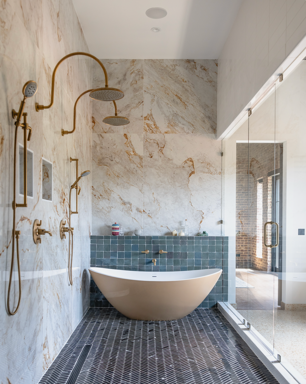 modern bathroom featuring a freestanding tub dual shower heads and textured wall tiles