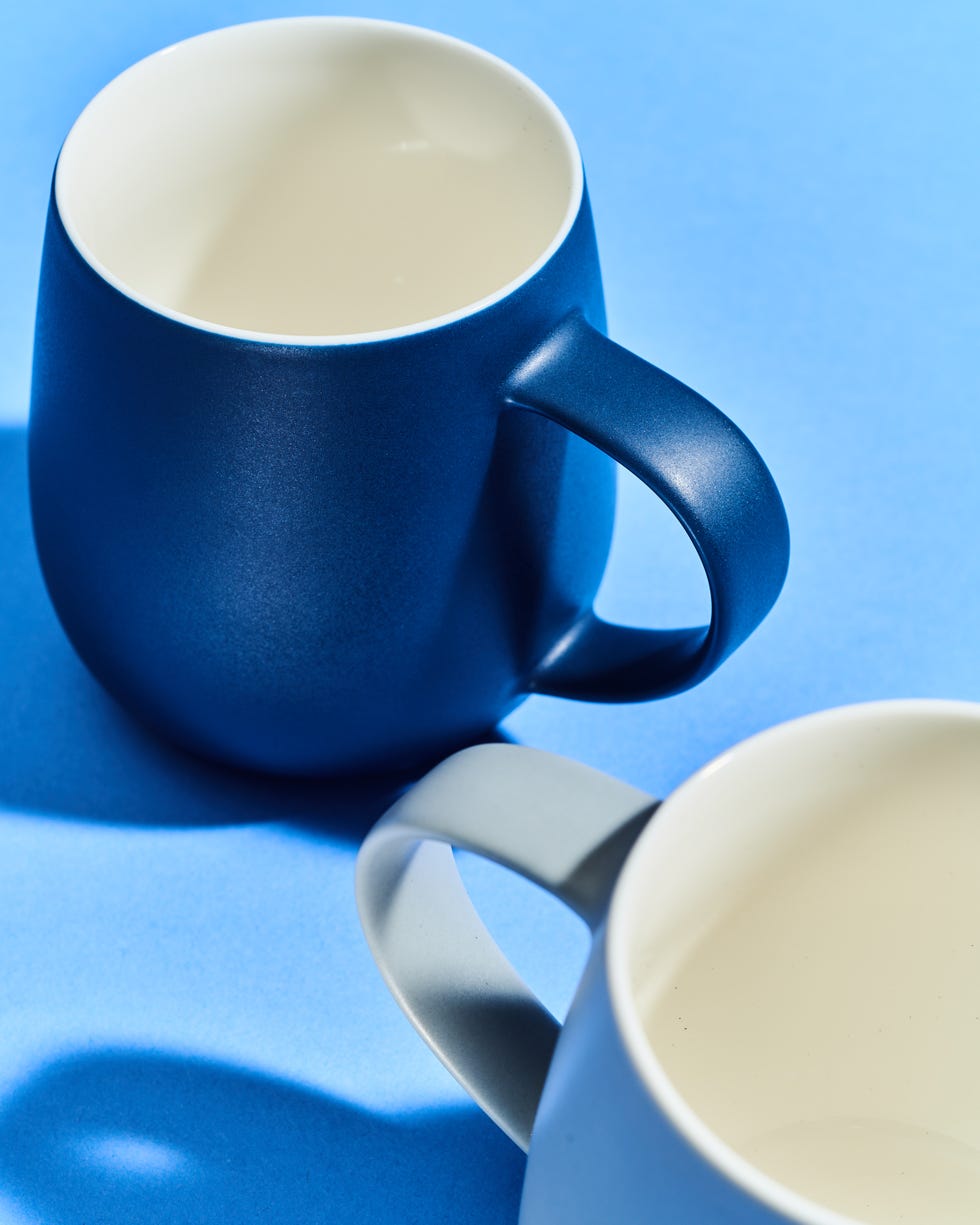 two mugs positioned at an angle on a blue background