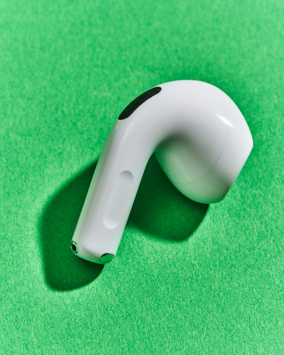 wireless earbud resting on a green surface