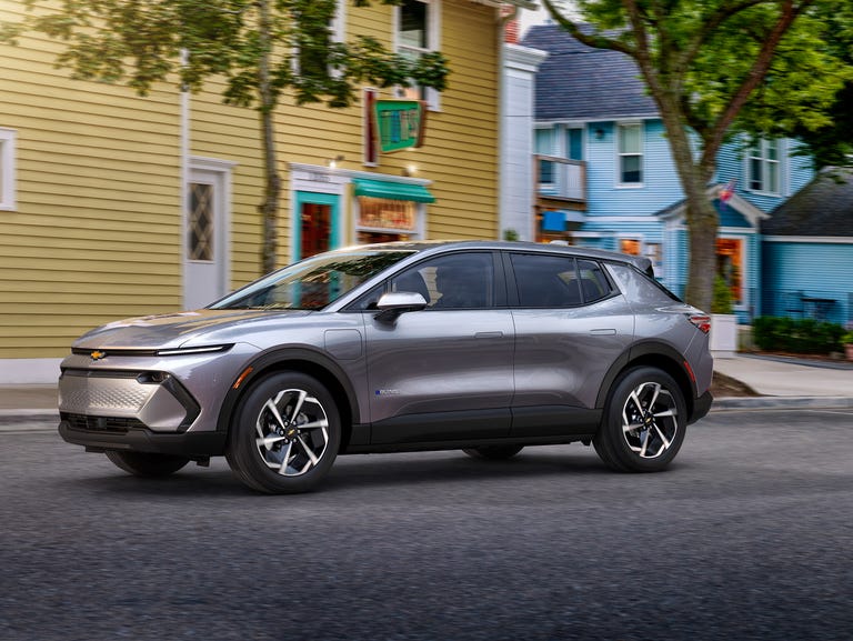 2024 chevrolet equinox ev driving down a small town street