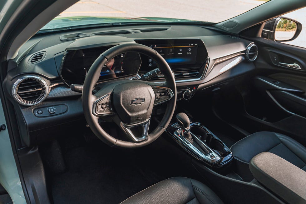 interior view of a compact suv's cabin, showing a steering wheel with a chevrolet logo, digital displays, and a center console.