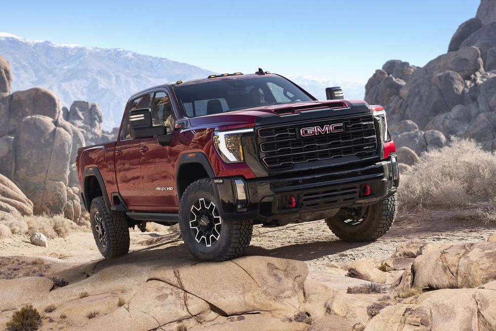 2024 gmc sierra 2500hd at4x in volcanic red tintcoat tackling rocky off road conditions