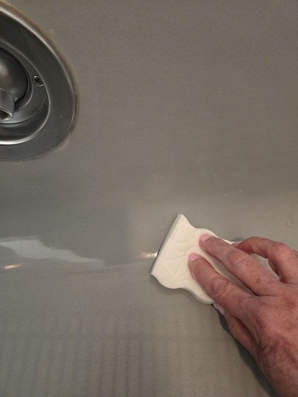 best shower cleaners testing a scrub pad on a tub