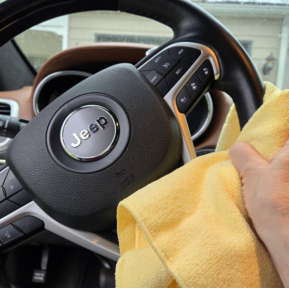 best car upholstery cleaners cleaning a steering wheel with a cloth