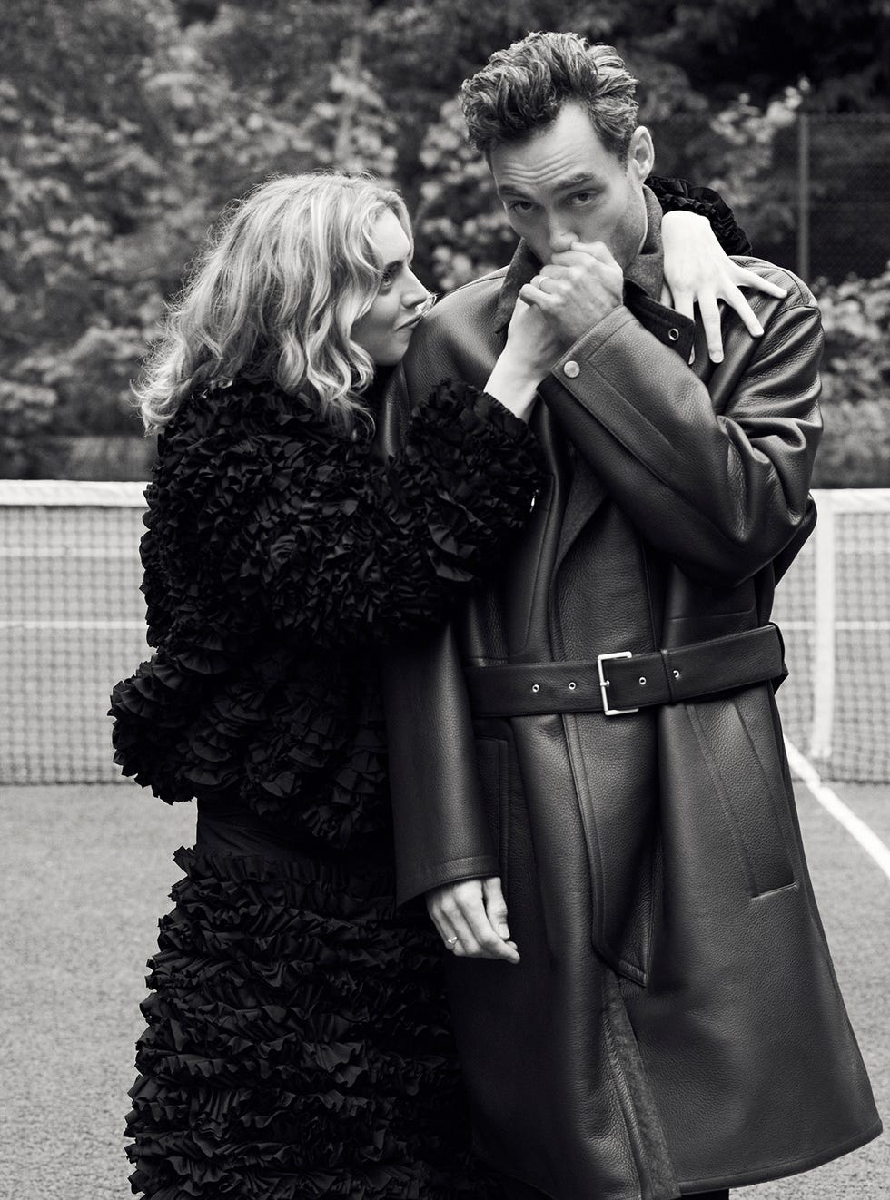 a scene featuring two individuals closely interacting on a tennis court