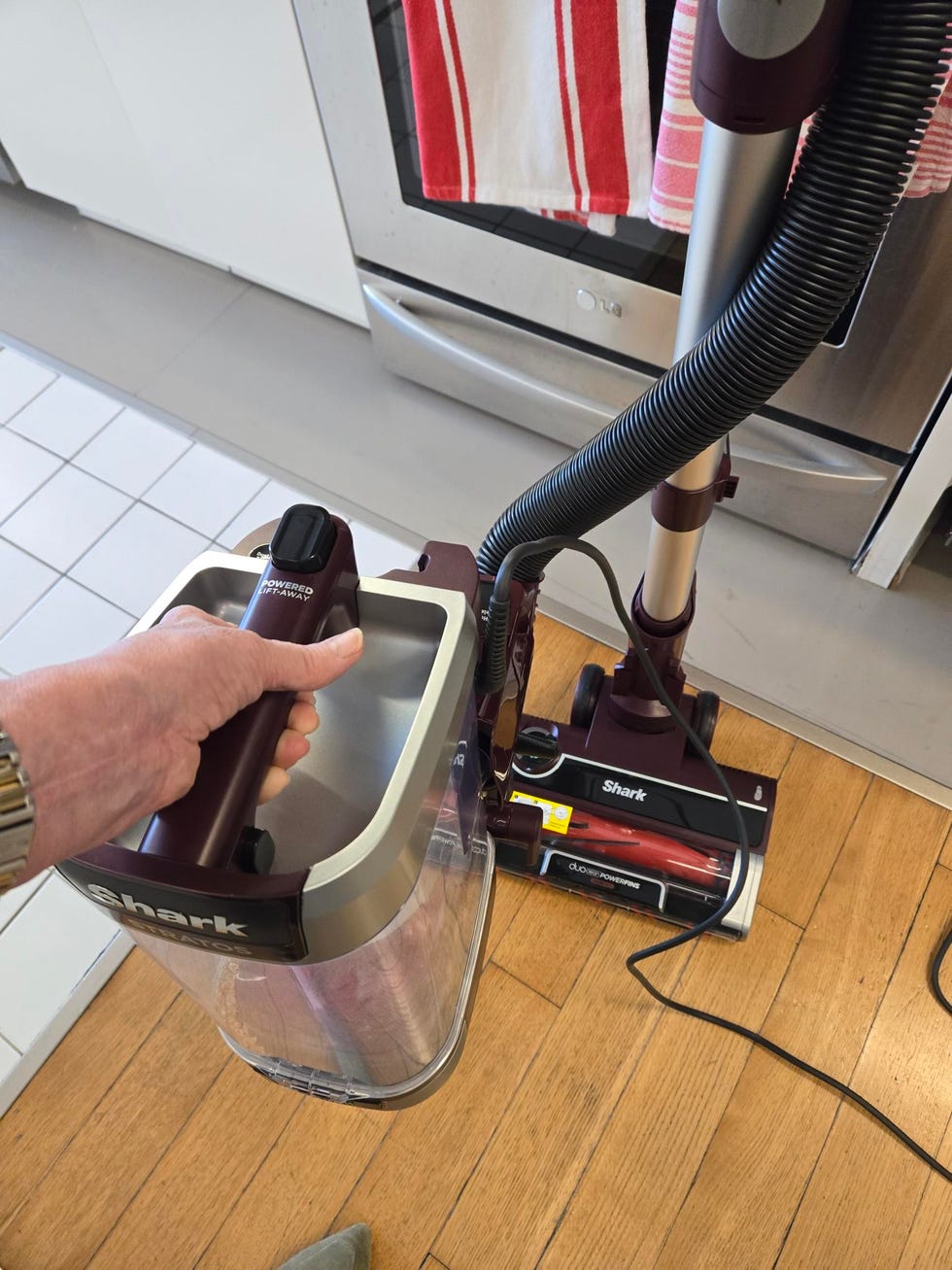 best vacuums for hardwood floors holding a removable canister from an upright vacuum