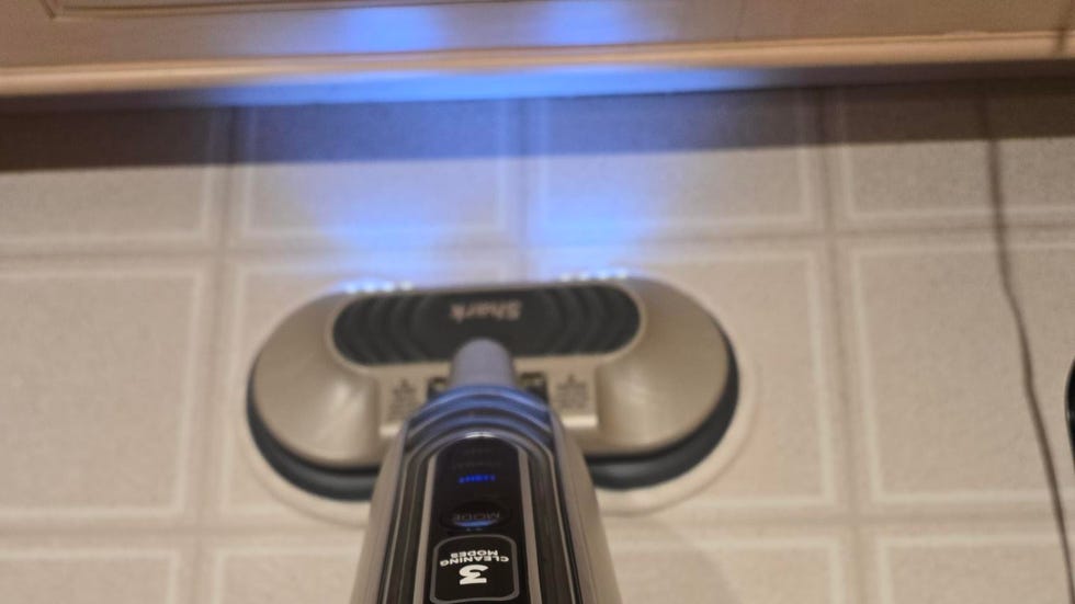 Best Steam Mops: Shark Steam & Scrub with Steam Blaster Technology gray and black shark steam mop being used on a tile floor