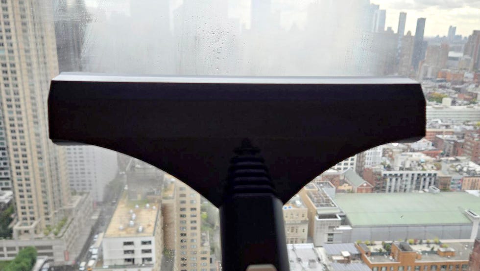 Best Steam Mops: Dupray Steam Cleaner cleaning a window with the dupray steam cleaner squeegee attachment