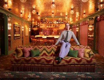 stylish lounge area with a vibrant couch and a bar in the background