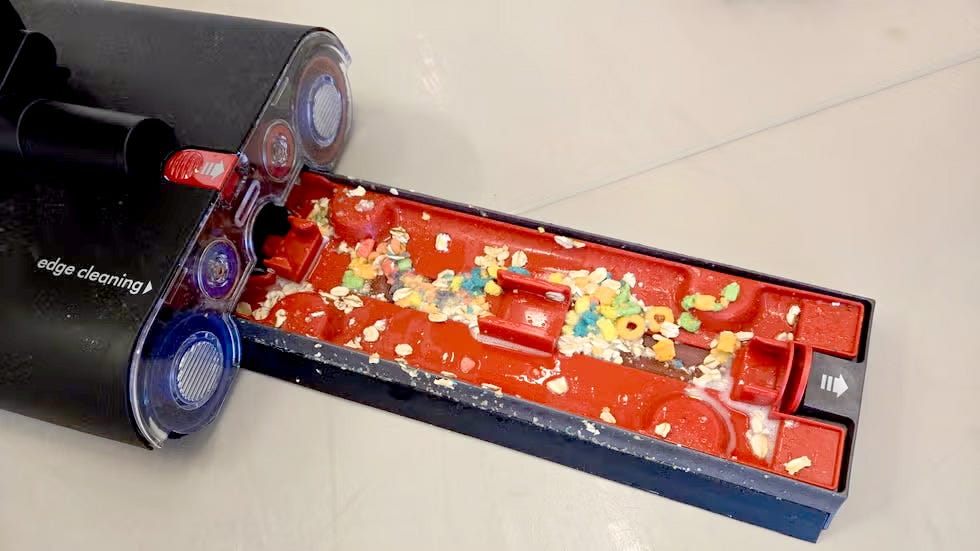 dyson washg1 wet floor cleaner with a visible debris tray filled with various food particles